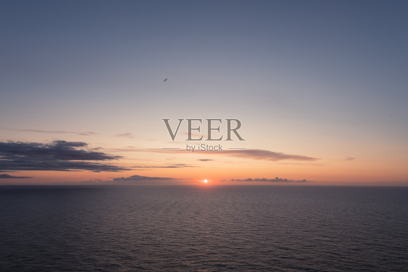 海洋中的日落与柔和的波浪照片摄影图片