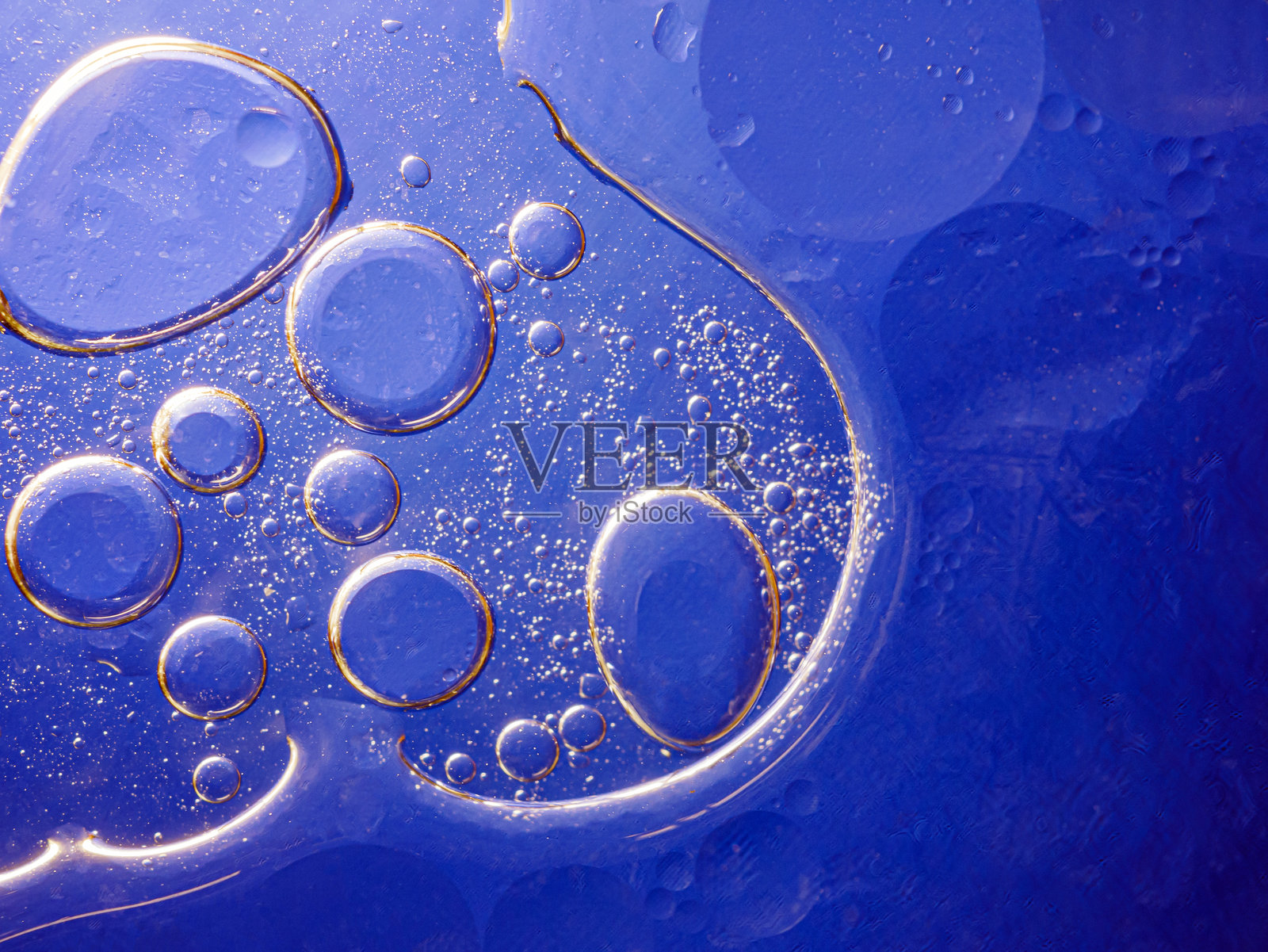蓝色背景上的气泡。蓝色背景下海绵中的抽象氧气泡水。蓝色圆形水泡。照片摄影图片