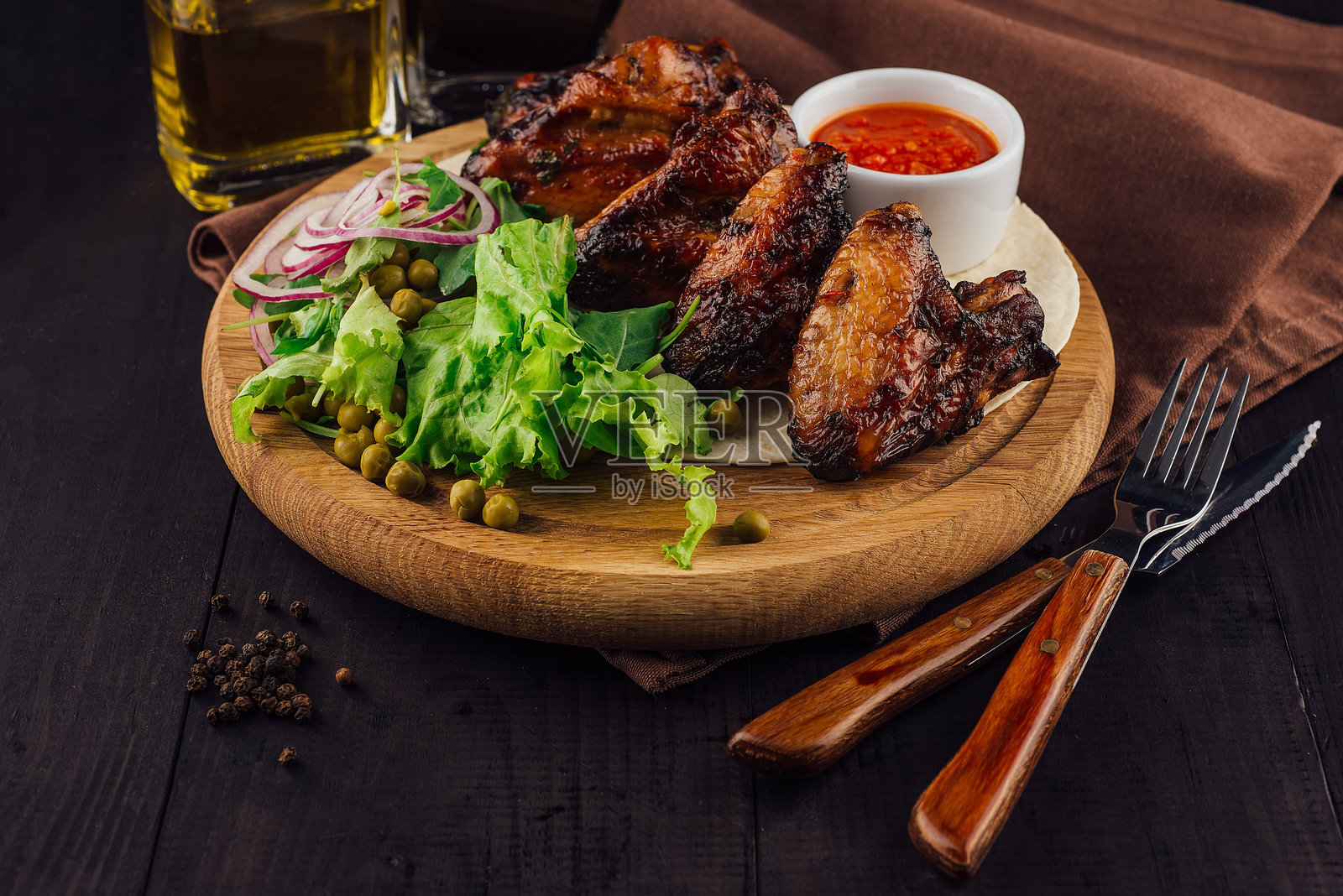 木板上摆放着沙拉的烤鸡翅照片摄影图片