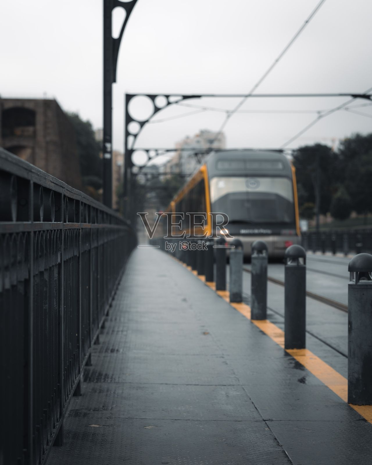 现代电车在雨中的桥上照片摄影图片