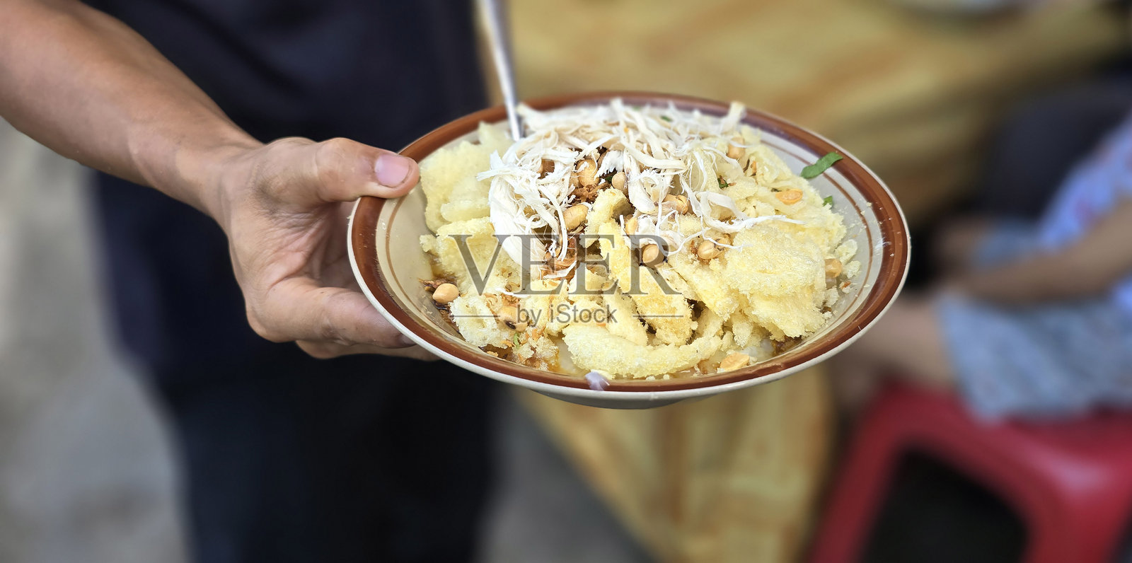 鸡肉粥（称为bubur ayam），配有饼干、切片葱和其他调料，是印尼街头美食之一。照片摄影图片