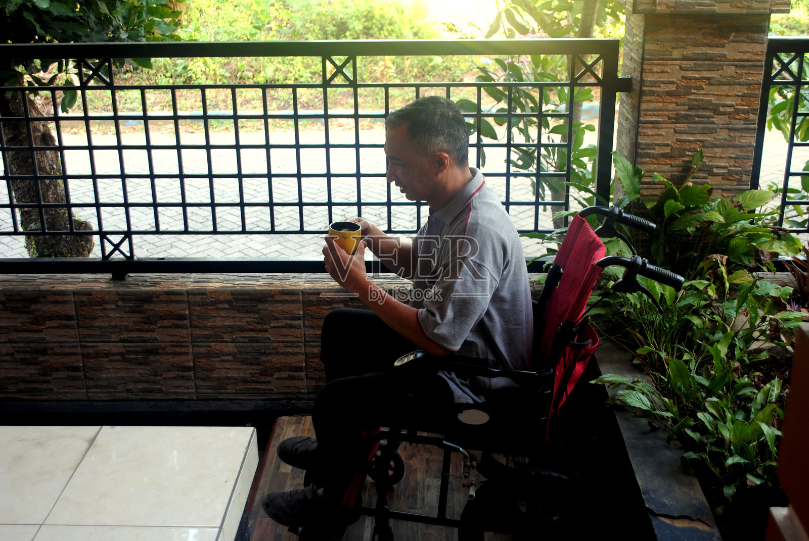 一名坐在轮椅上的男子在家中放松。照片摄影图片