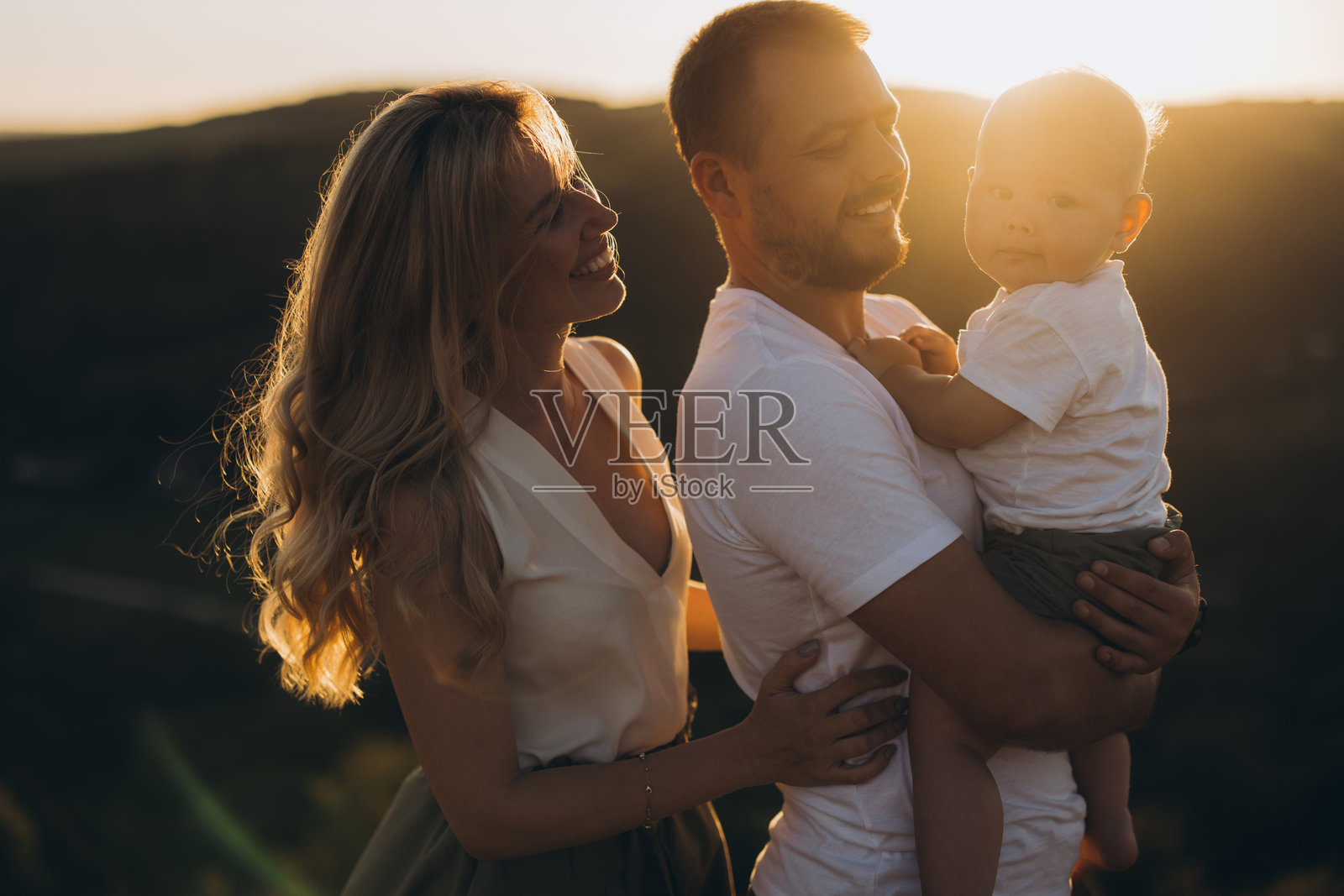 快乐的家庭在阳光明媚的自然场景中一起享受日落照片摄影图片