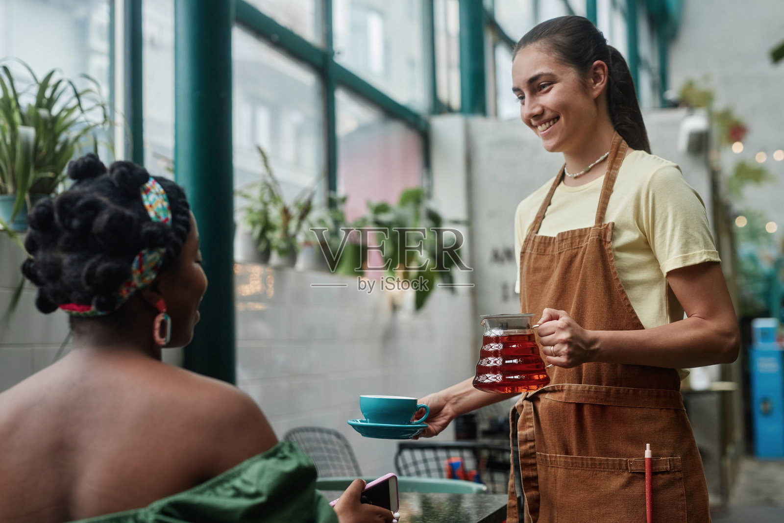 微笑的女服务员为桌子服务照片摄影图片