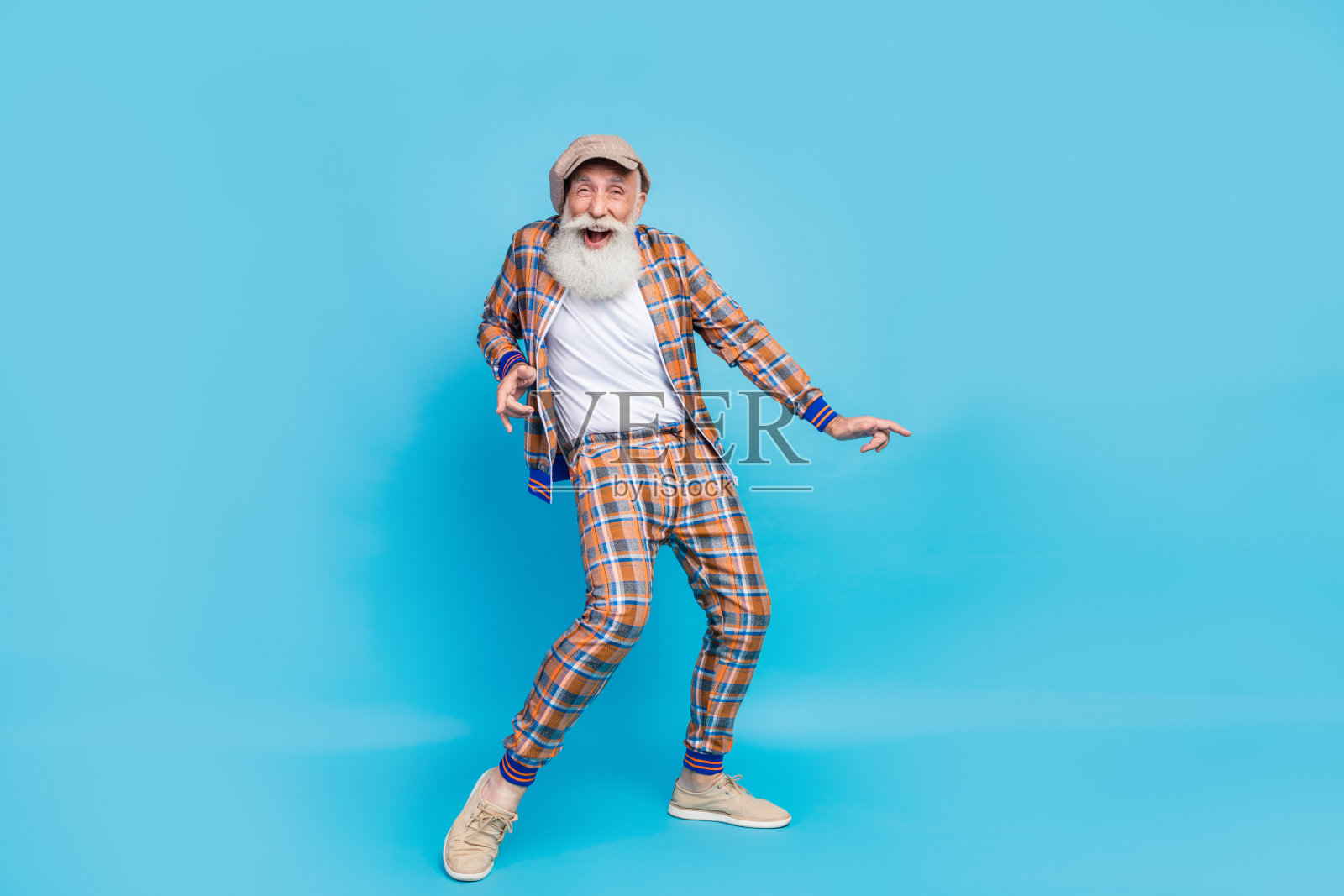 穿着时尚复古西装的疯狂兴奋的老年人全身照，庆祝生日活动，放松休息，背景为蓝色。照片摄影图片
