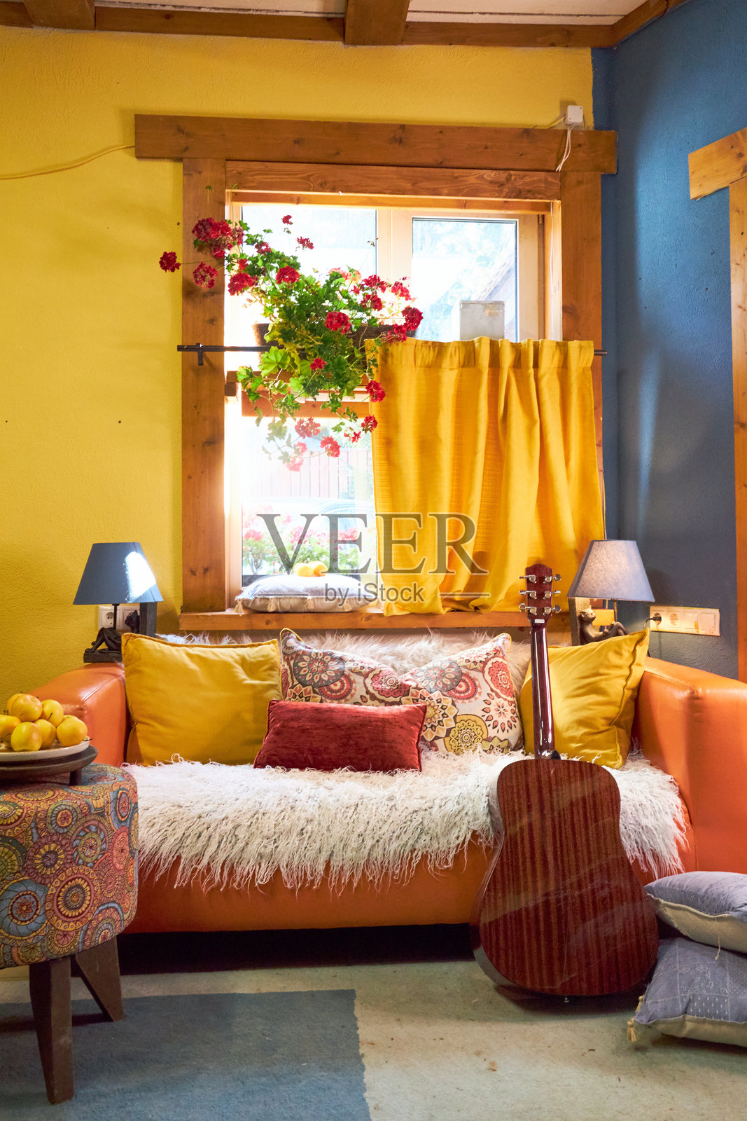 设计一个创意工作坊的室内，采用黄色和蓝色调，配有橙色沙发和多彩的靠垫。照片摄影图片