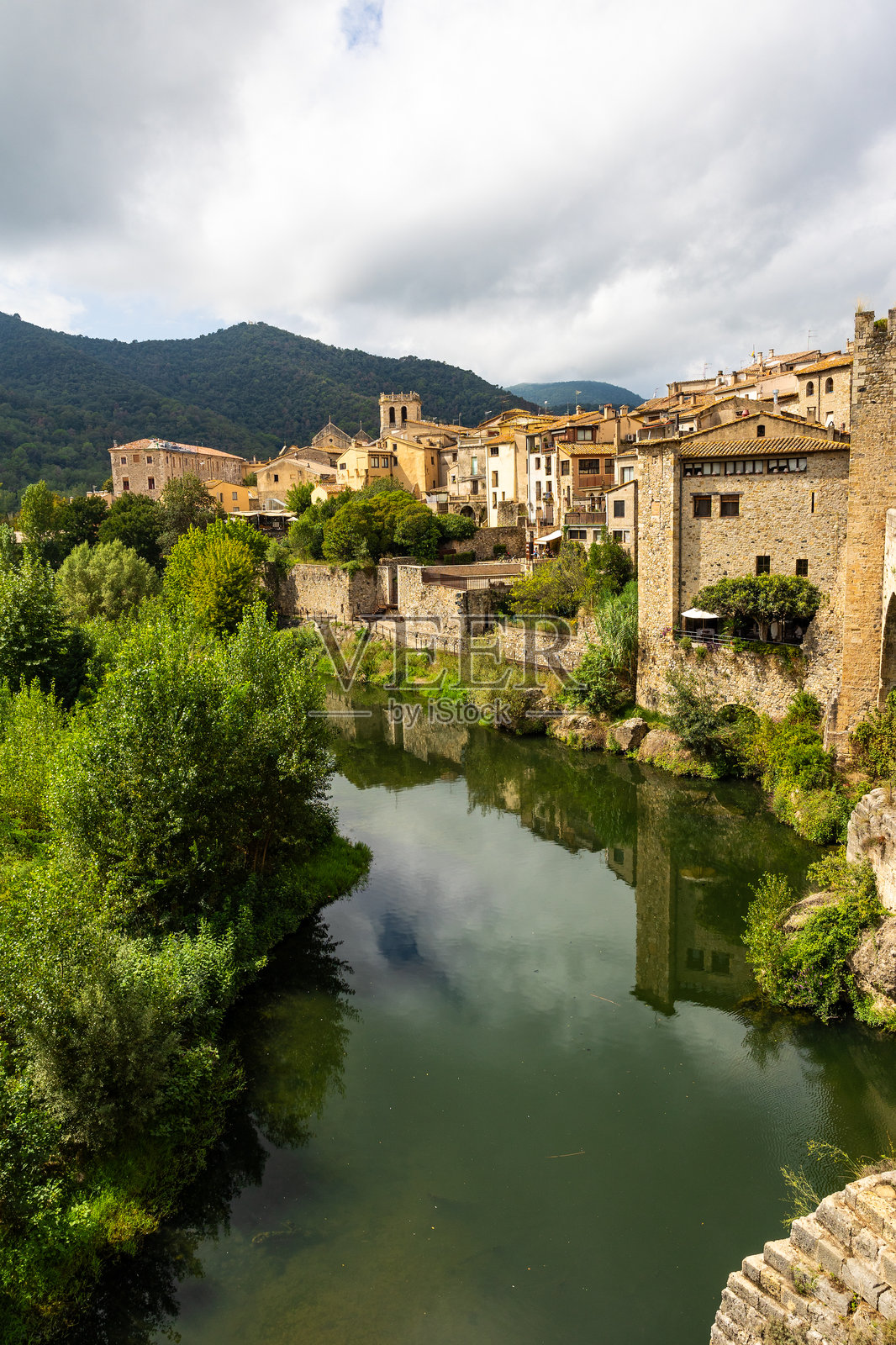 西班牙贝萨卢的中世纪村庄，从跨越弗鲁维亚河的防御桥上俯瞰照片摄影图片