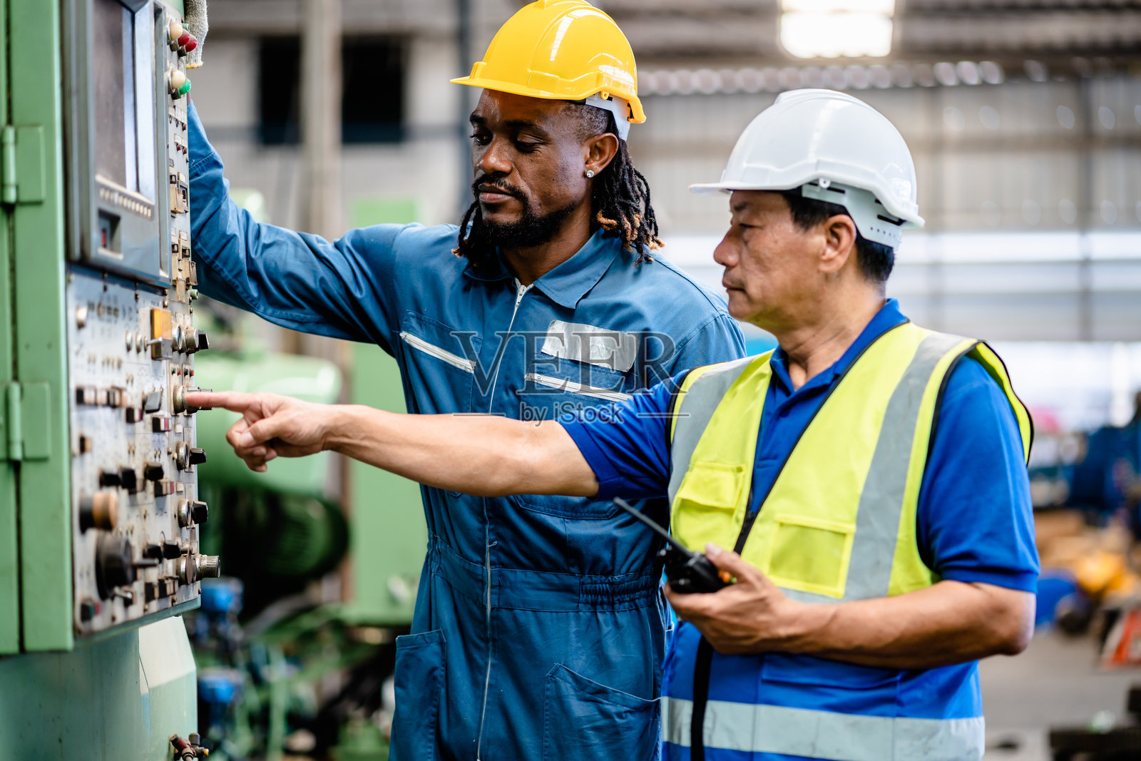 工程师和非裔美国男性工厂技术员操作和检查数控机床车间维修，工业机械工程师。照片摄影图片