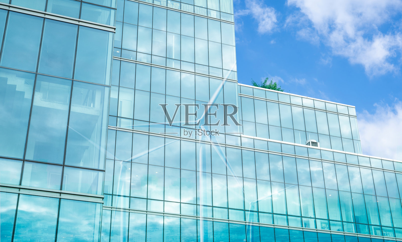 绿色企业建筑，风轮机的影子投射在玻璃立面上。可持续能源和高效建筑设计。生态友好型现代化城市建设。可持续的经济增长。照片摄影图片