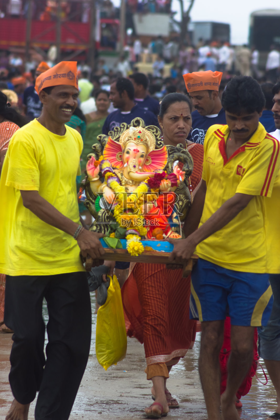 奉献者将印度教的甘尼萨神带入海洋照片摄影图片