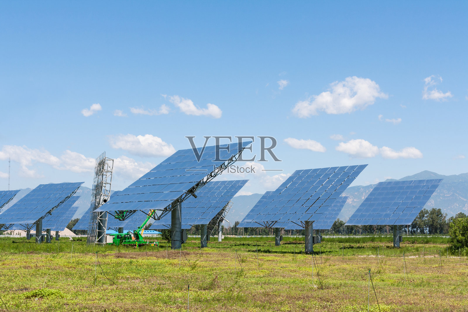 草地上光伏太阳能发电站照片摄影图片