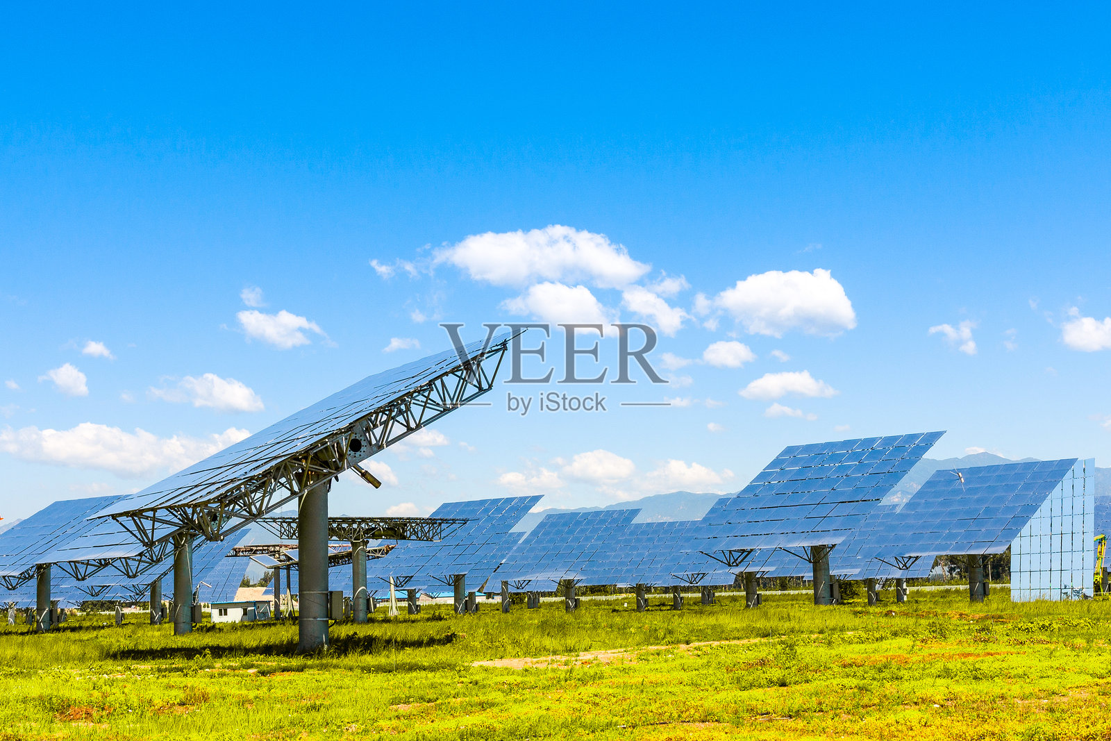 草地上光伏太阳能发电站照片摄影图片