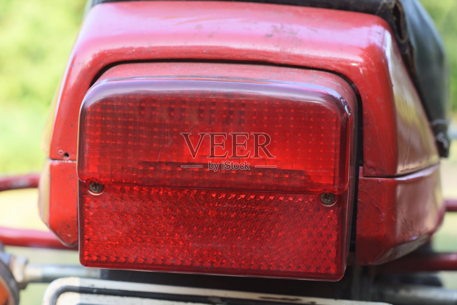 一只大红色塑料尾灯装在一辆老摩托车上照片摄影图片