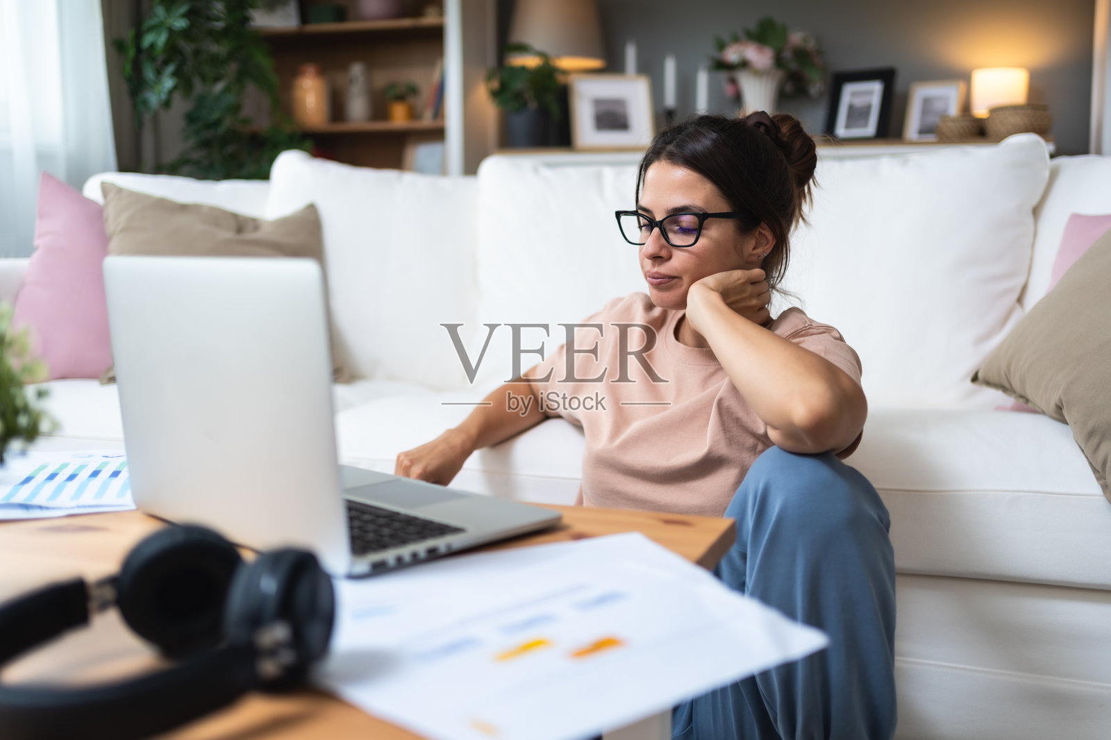 年轻疲惫、沮丧且过度工作的自由职业女性在家工作，感受到工作带来的疲惫和精疲力竭。专业的金融和经济女性专家在视频通话后感到疲惫不堪。照片摄影图片