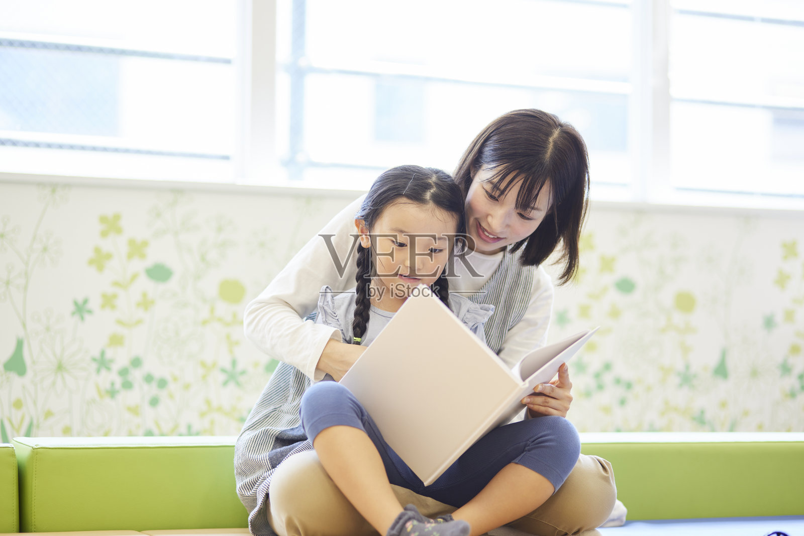 一位女老师在幼儿园里与孩子们一起看图画书照片摄影图片