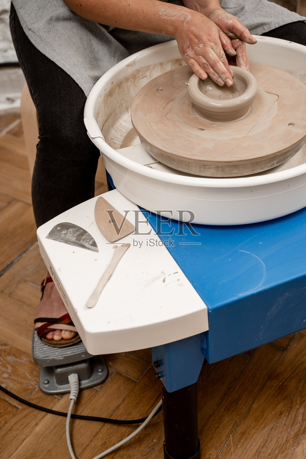 在陶艺课上自己制作陶瓷碗。使用陶轮成型。学习如何用陶轮将粘土塑造成不同形状。照片摄影图片