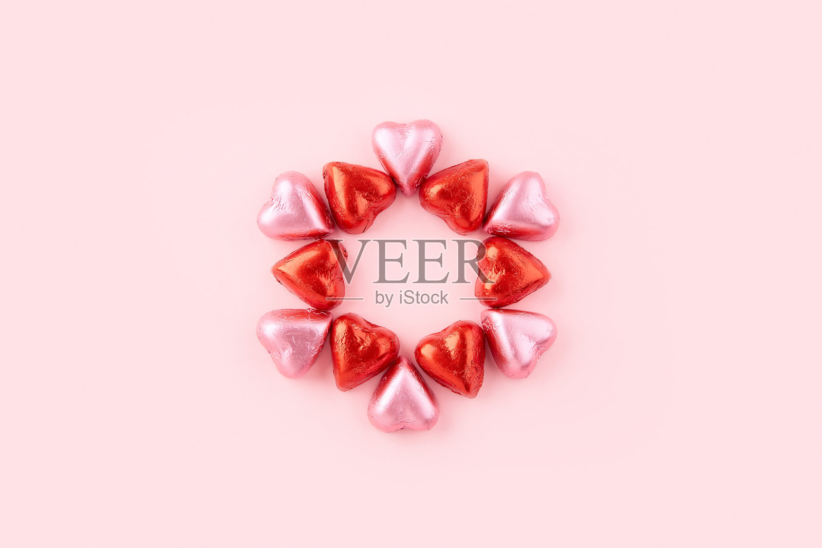 粉色背景上的心形巧克力糖果圈照片摄影图片