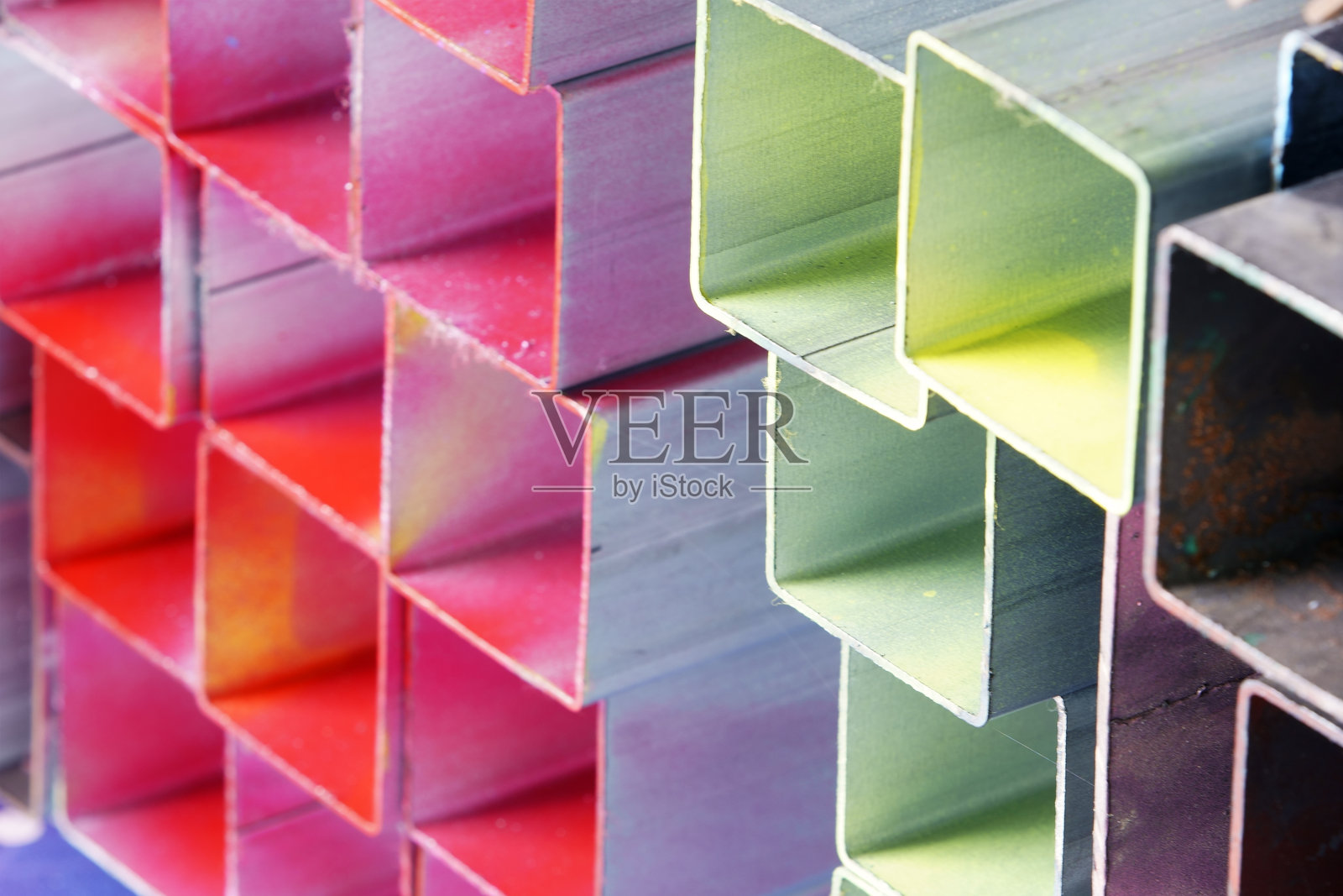 色彩斑斓的金属管以艺术方式堆叠在一起照片摄影图片