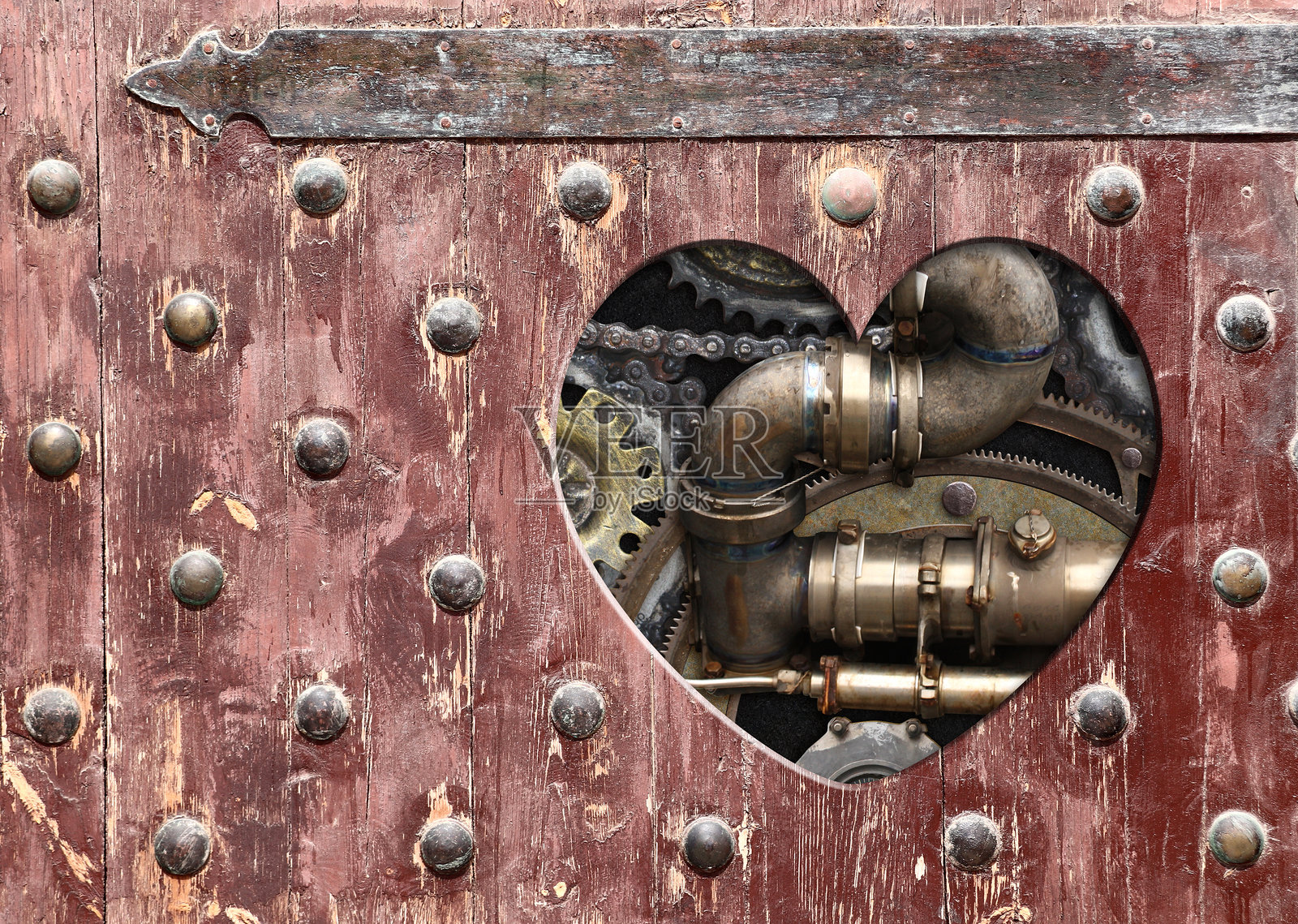 复古风格的蒸汽朋克背景，木板上有心形孔，配有复古金属机械细节、管道和齿轮。留有文本空白，可用于工业和机械设计。照片摄影图片