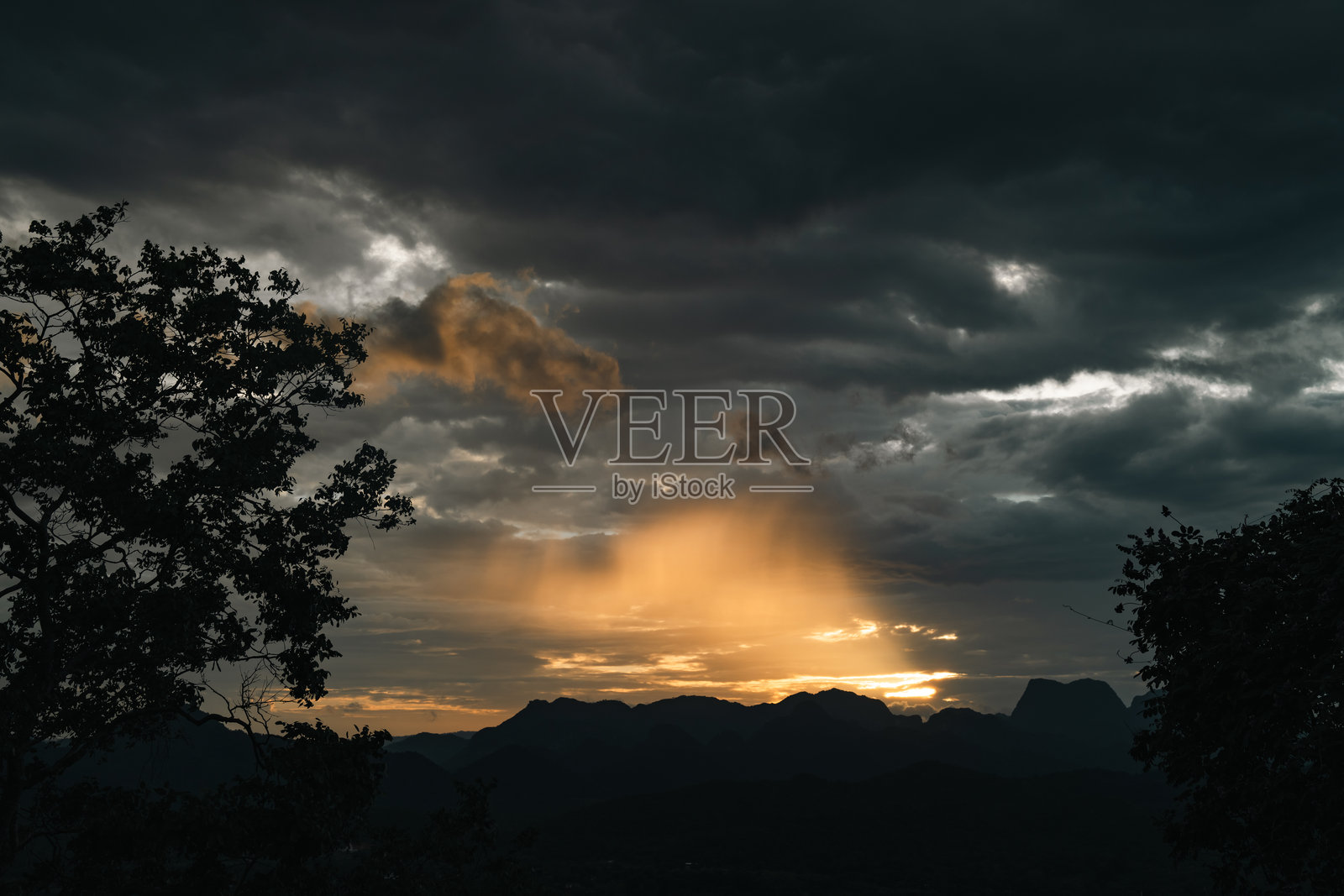 壮丽的山脉在日落时分，天空和云彩交织，美丽的风景在傍晚的光线中被捕捉，夕阳西下，地平线泛着橙色光辉，从黄昏过渡到黎明，阳光洒落。照片摄影图片