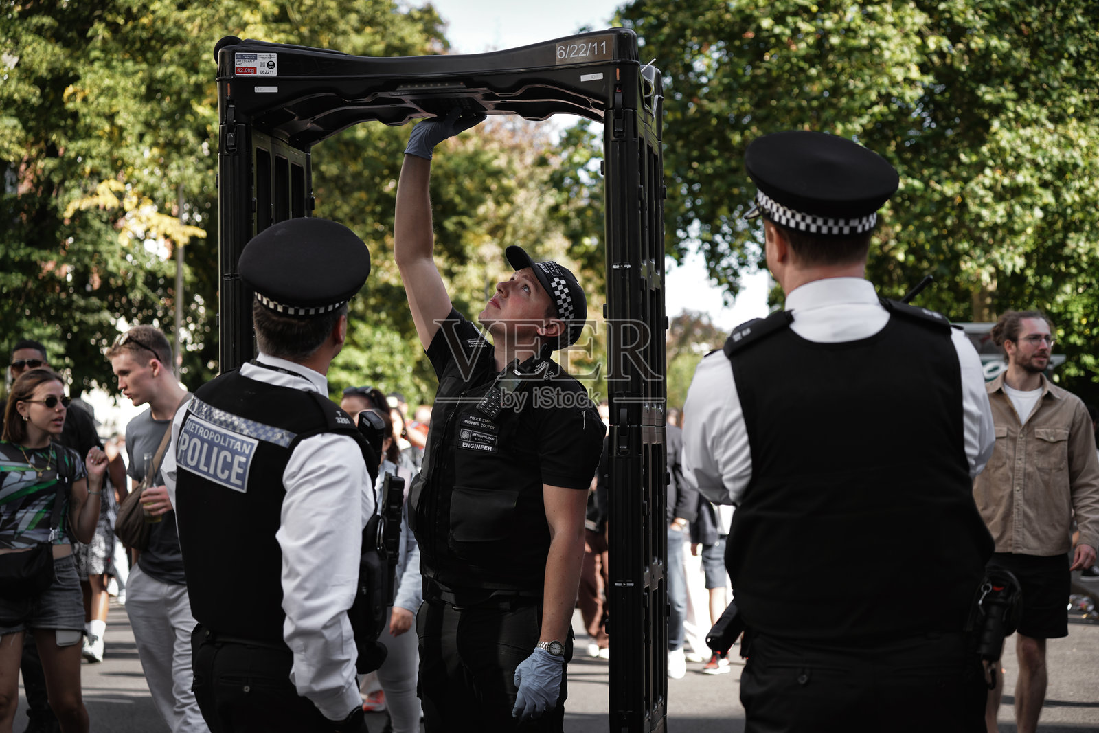 英国警察在诺丁山狂欢节街头维护公共安全，金属探测器和临时安全门照片摄影图片