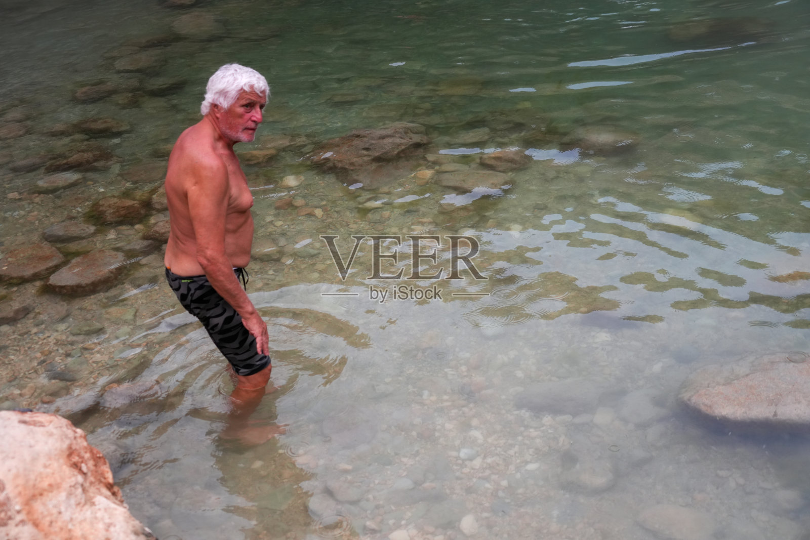 游客在阿曼Al Sharqiyah的Bimmah天坑（当地名称Hawiyyat Najm）水潭中戏水照片摄影图片