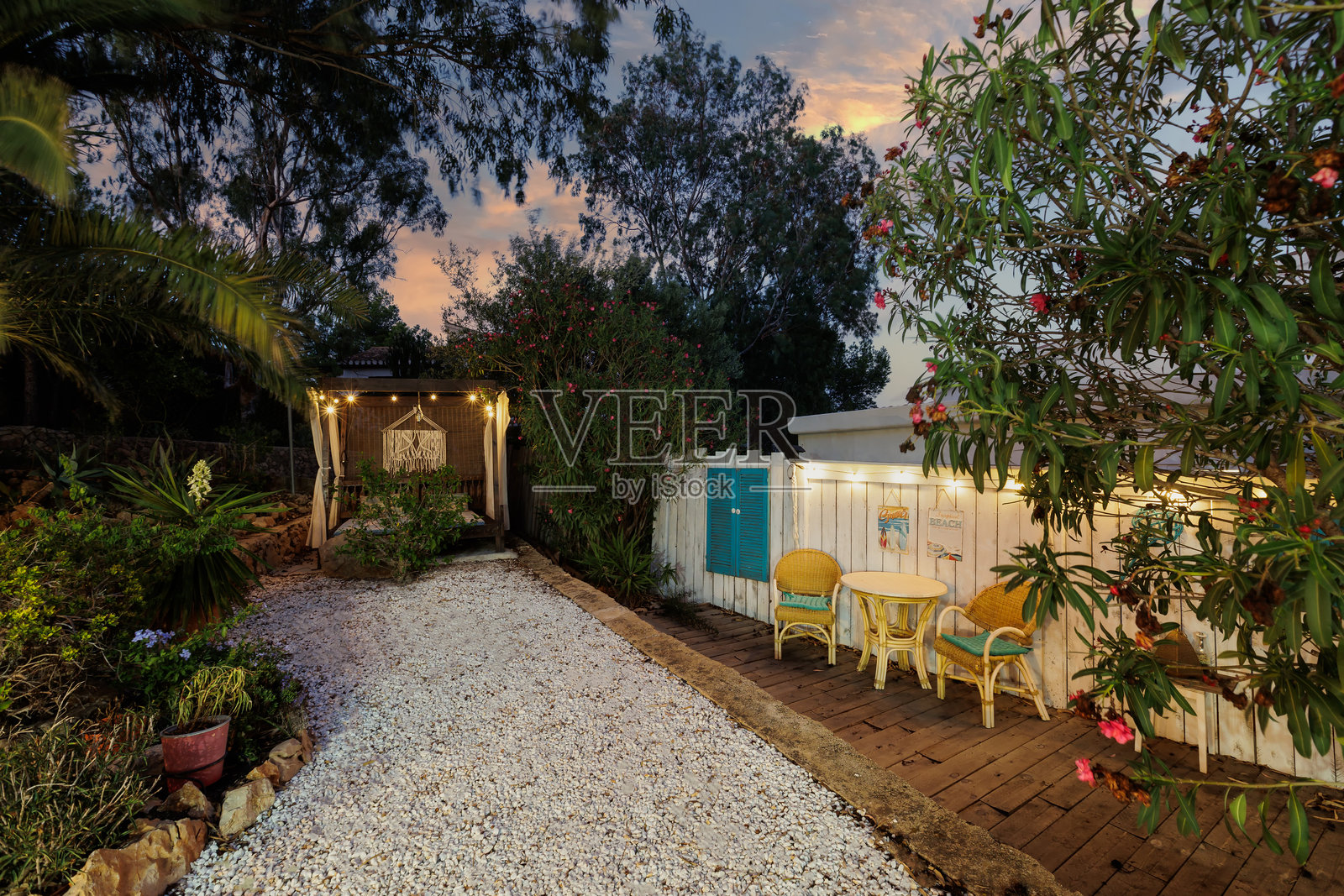 傍晚时分的花园与木制凉亭。照片摄影图片