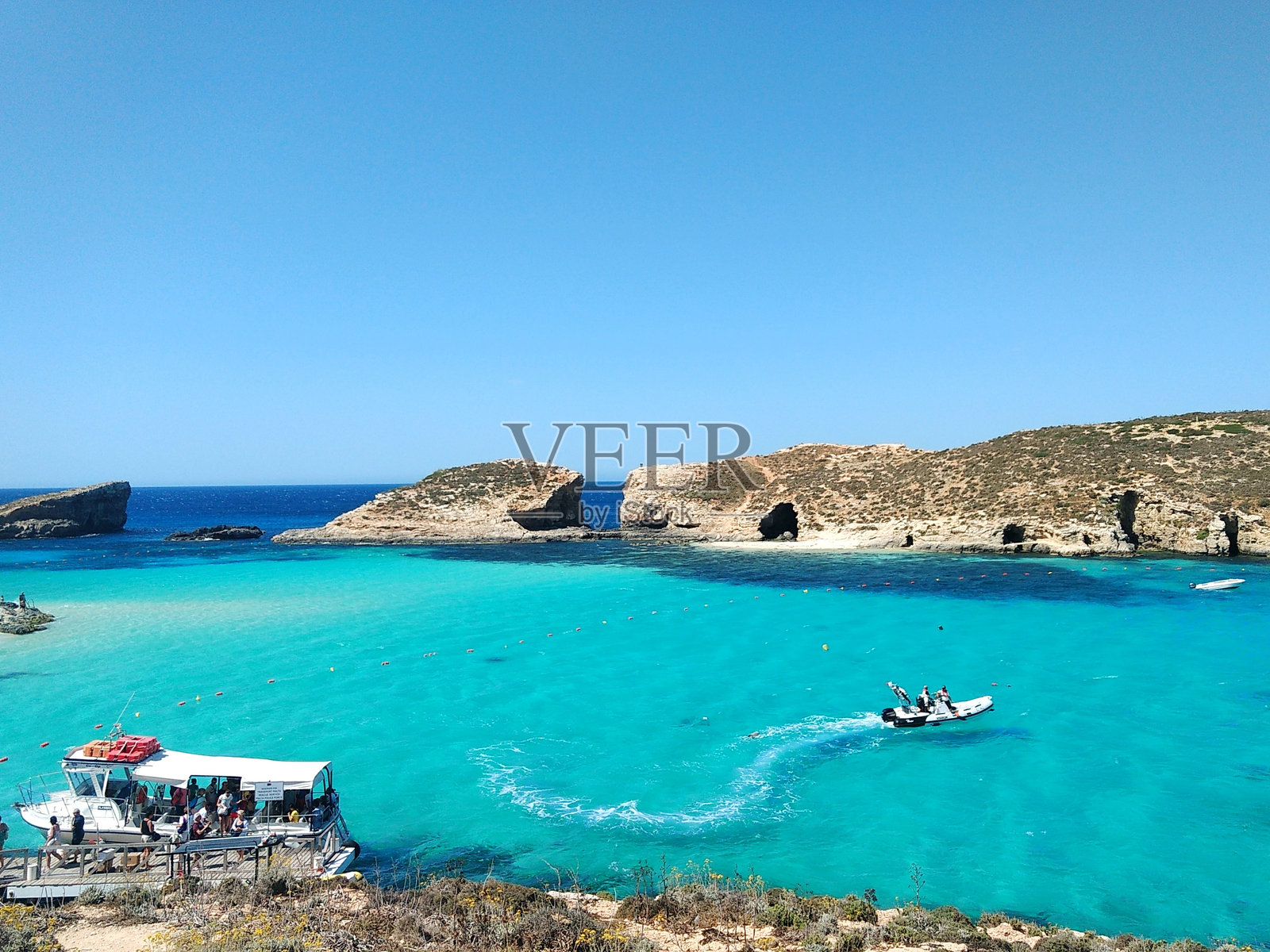 人们在海上划船，背景是晴朗的天空照片摄影图片