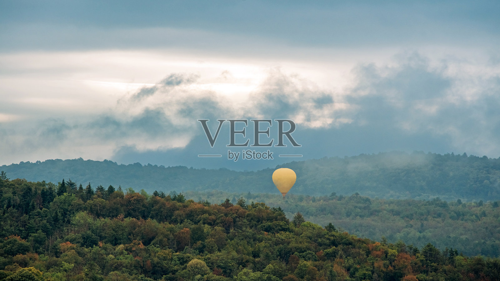 热气球漂浮在雾蒙蒙的山中照片摄影图片