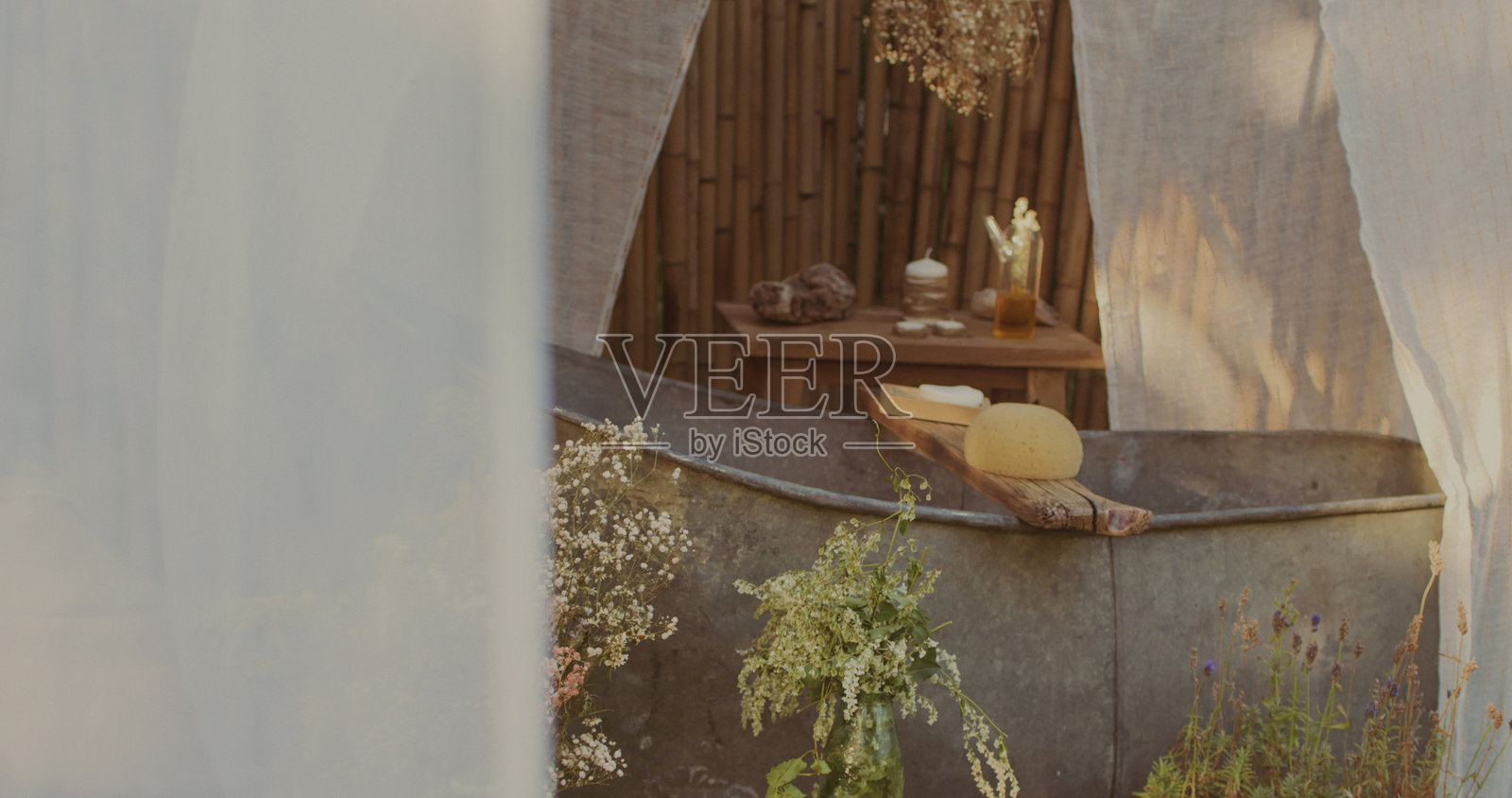 春季花园中的户外浴缸设置。被绿植环绕的草本水疗疗法照片摄影图片