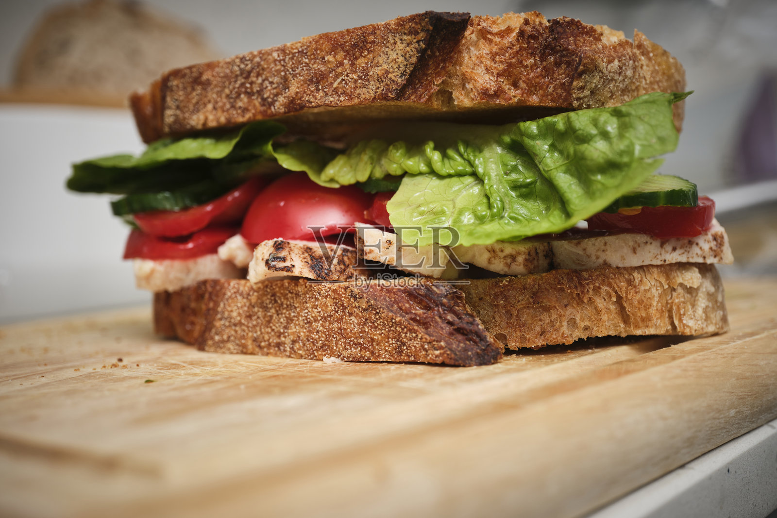 自制鸡肉沙拉三明治放在木砧板上。照片摄影图片