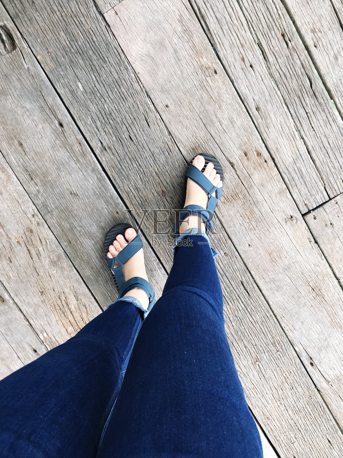 女人穿着拖鞋的脚在木质背景上的自拍照。照片摄影图片