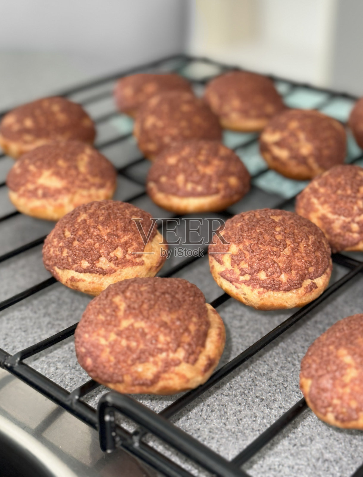 自制泡芙，法式糕点在你自己的厨房，带有脆皮的泡芙，奶油泡芙食谱，如何制作泡芙，泡芙，闪电泡，烘焙盘上许多泡芙在烤箱中。照片摄影图片