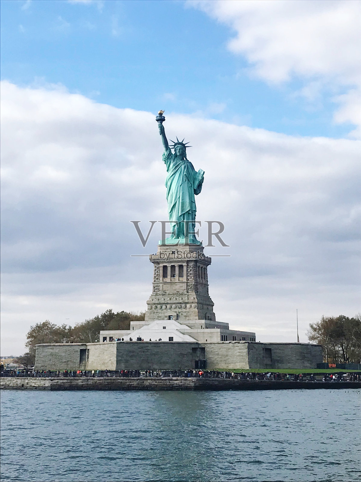 海滨的自由女神像与多云的天空相映衬照片摄影图片