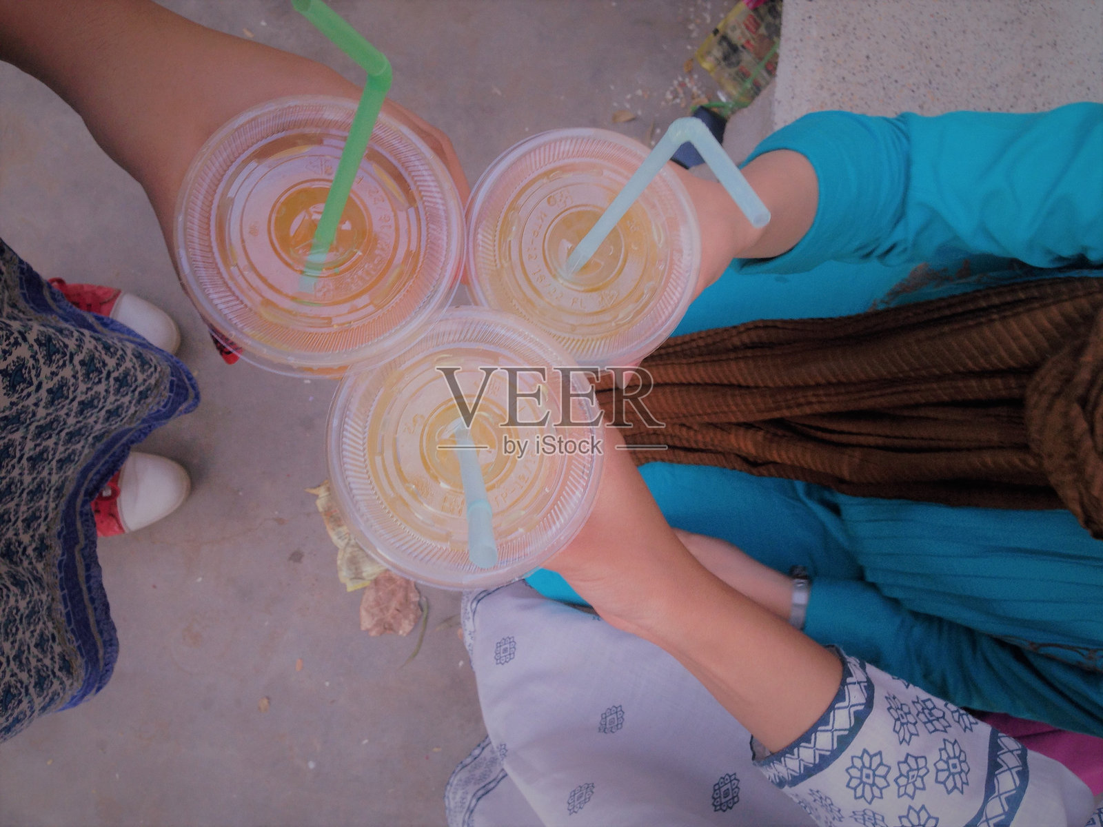 女性朋友们低头拿着一次性杯子的果汁照片摄影图片