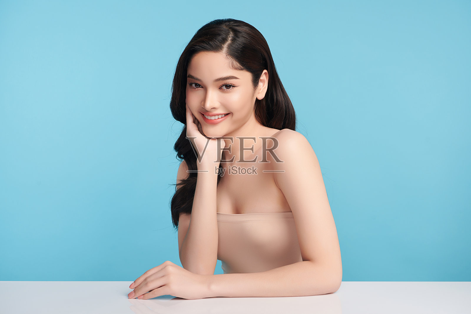 美丽的年轻亚洲女性，肤色洁净清新，背景为蓝色，面部护理，面部治疗，美容学，美容与水疗，亚洲女性肖像。照片摄影图片