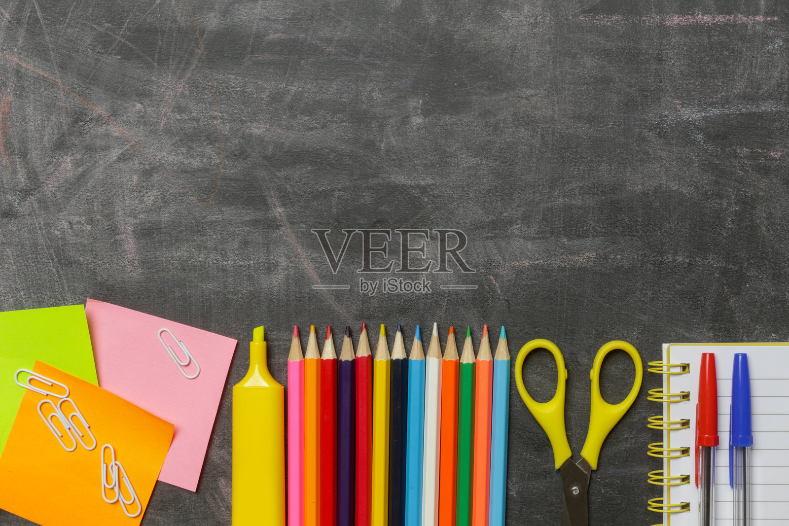 返校概念，黑色黑板背景上摆放着各种办公和学校用品。照片摄影图片