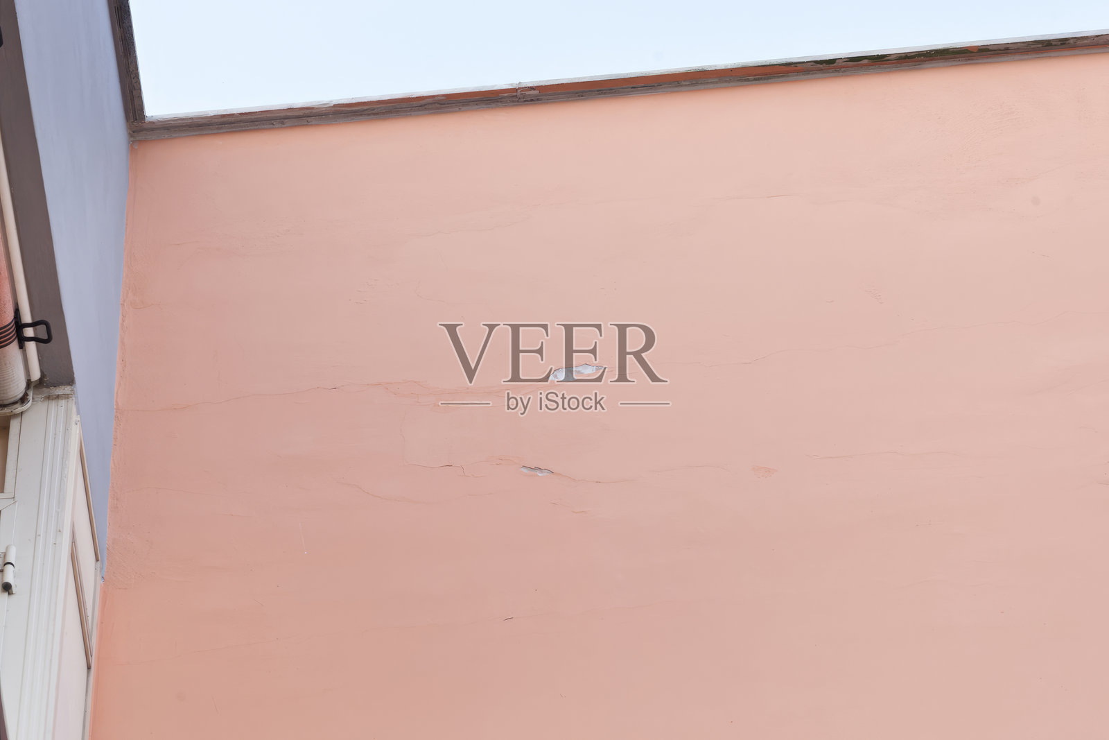 老化的粉色墙壁，明显的裂缝，强调了翻新和维护的紧迫性照片摄影图片