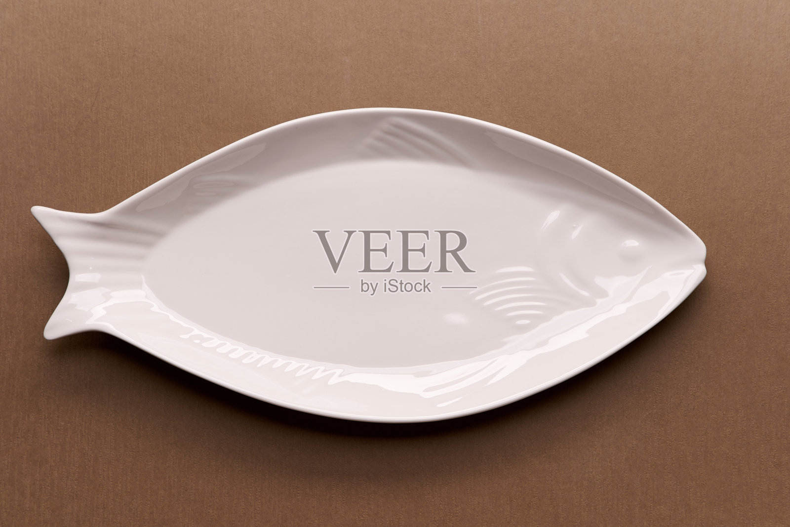 高角度视图的鱼形空盘子放在桌子上照片摄影图片