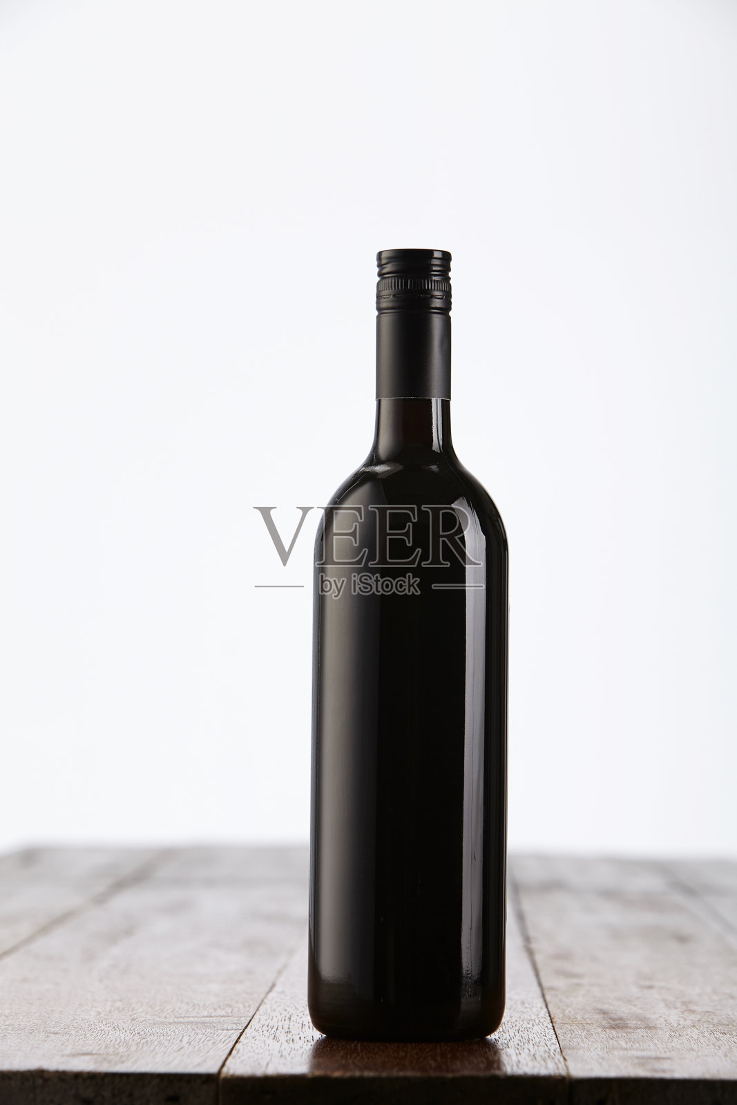 白色背景下桌子上的酒瓶特写照片摄影图片