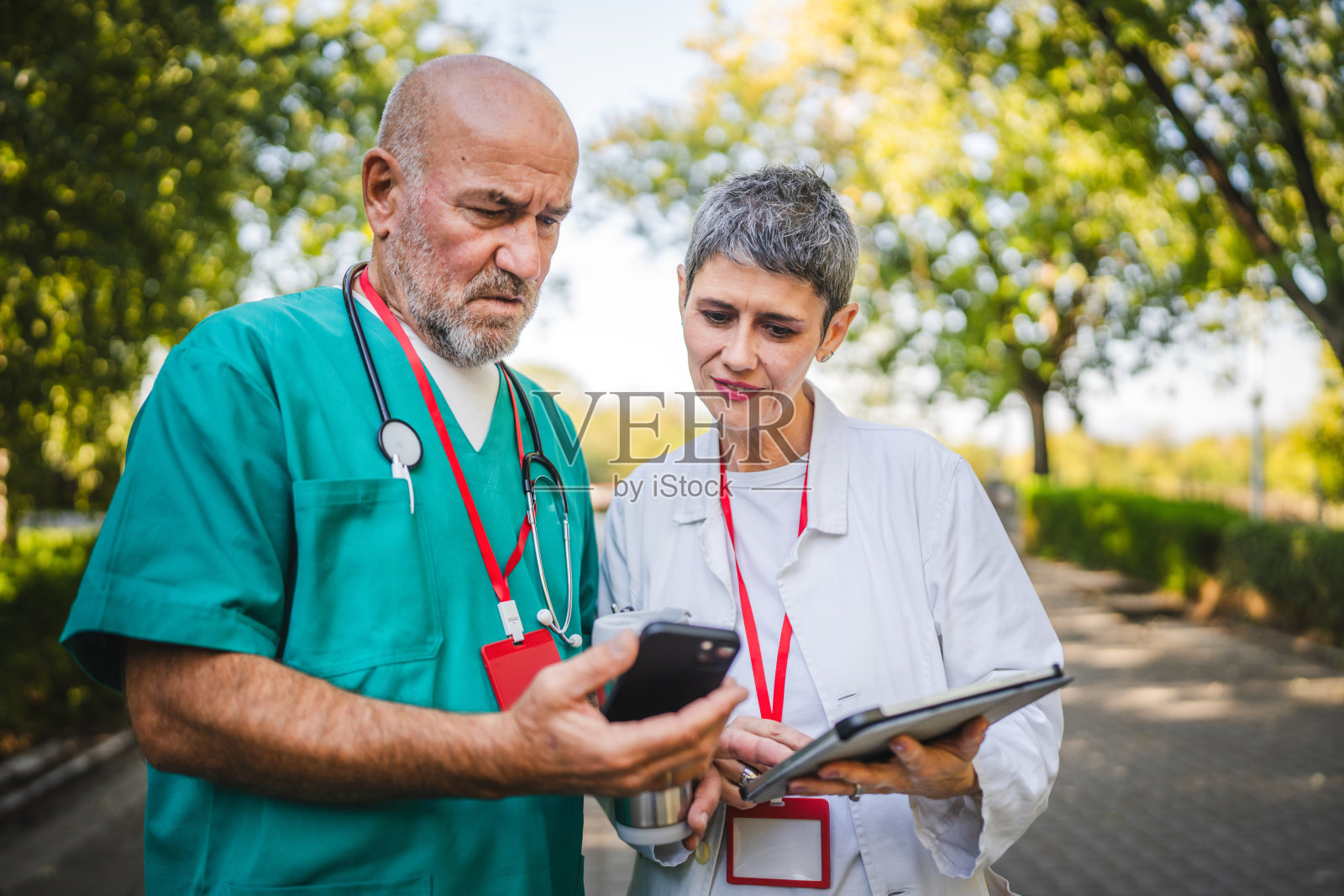 两位医生在手机和数字平板上查看数据照片摄影图片