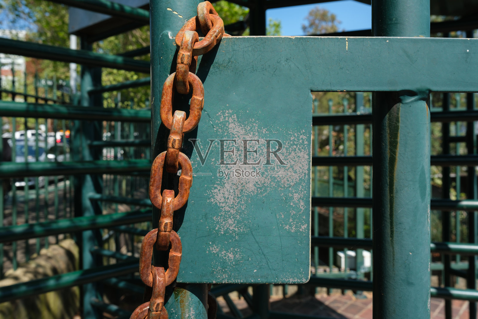 绿色围栏上的生锈链条照片摄影图片