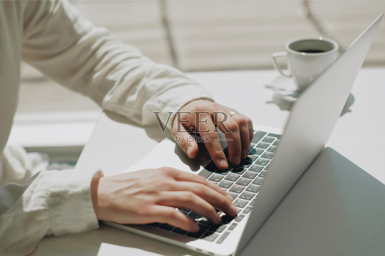 男子在桌子上使用笔记本电脑的中部特写照片摄影图片