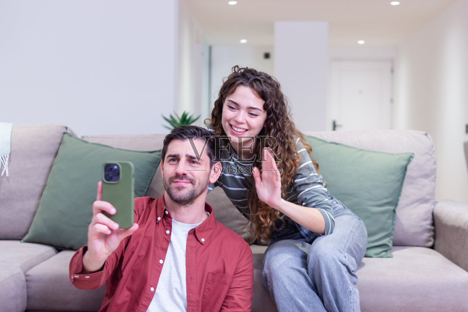 快乐的情侣在家用智能手机与朋友视频通话照片摄影图片