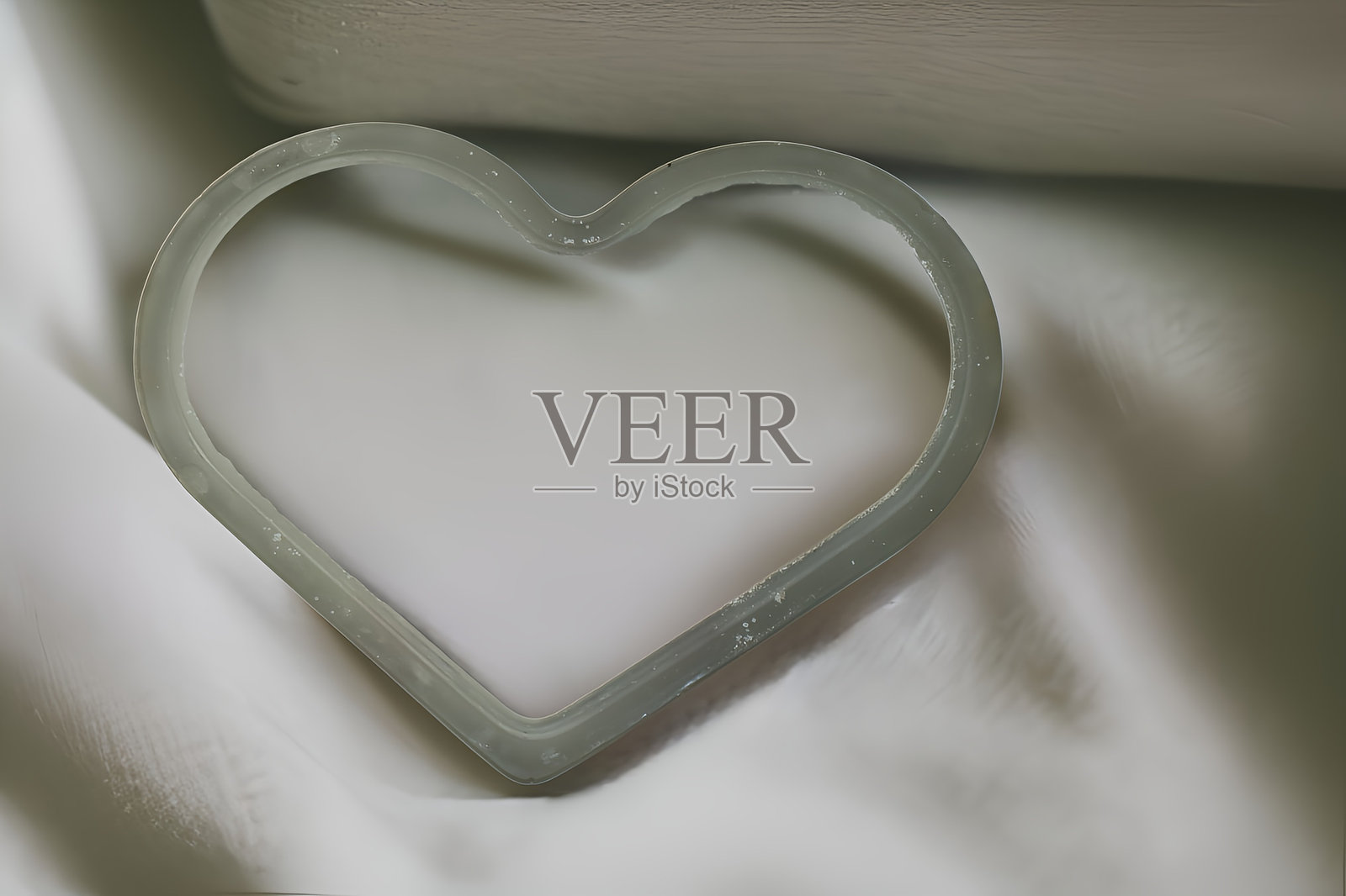 丝绸面料上的瓷质心形摆件照片摄影图片