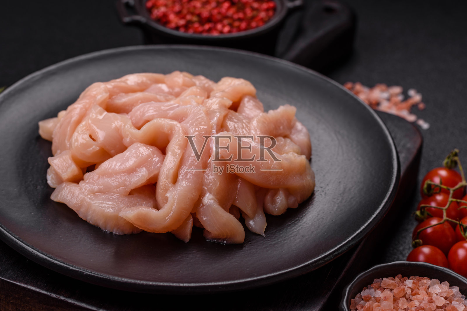 切成条状的生鸡胸肉，配以香料和草药照片摄影图片