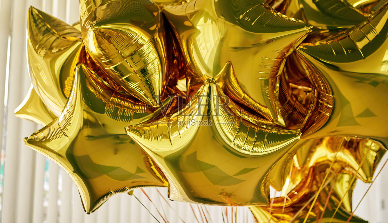 金色星形气球聚集在一起，点亮了室内庆祝活动的节日装饰照片摄影图片