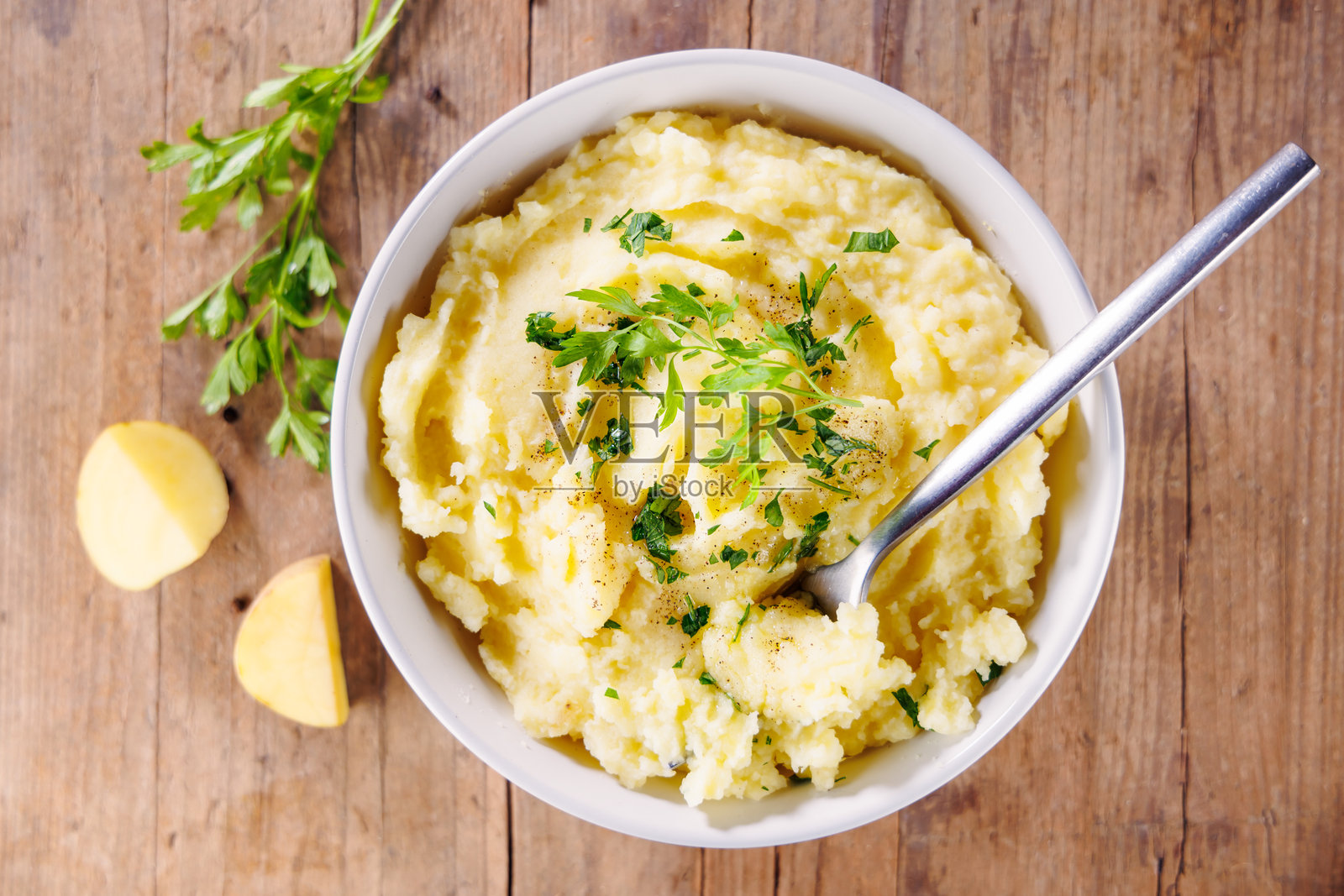 木桌背景上的碗中盛着土豆泥的俯视图，奶油般的舒适美食照片摄影图片