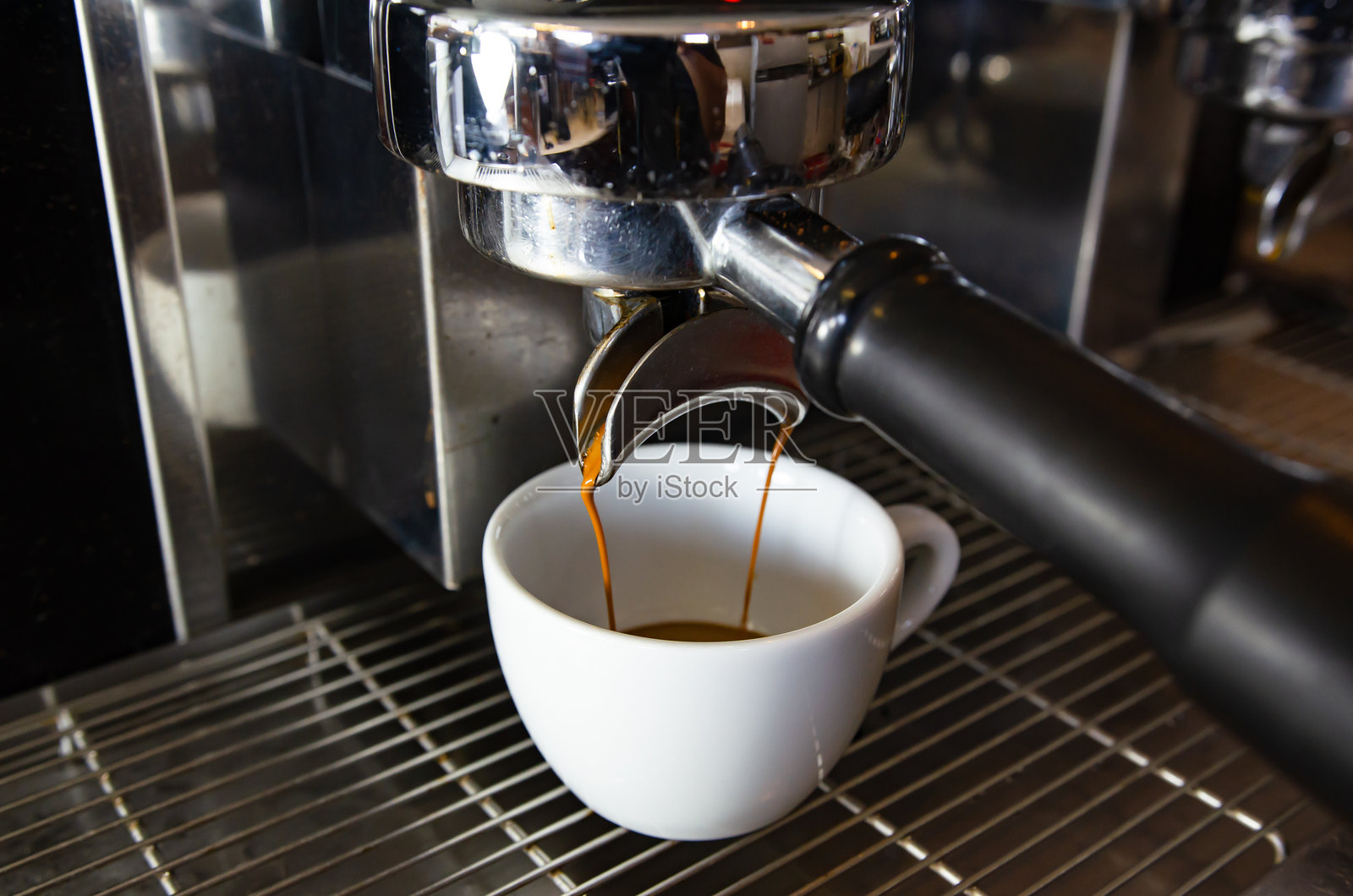 咖啡馆内浓缩咖啡机特写镜头，正在将咖啡倒入杯中。照片摄影图片