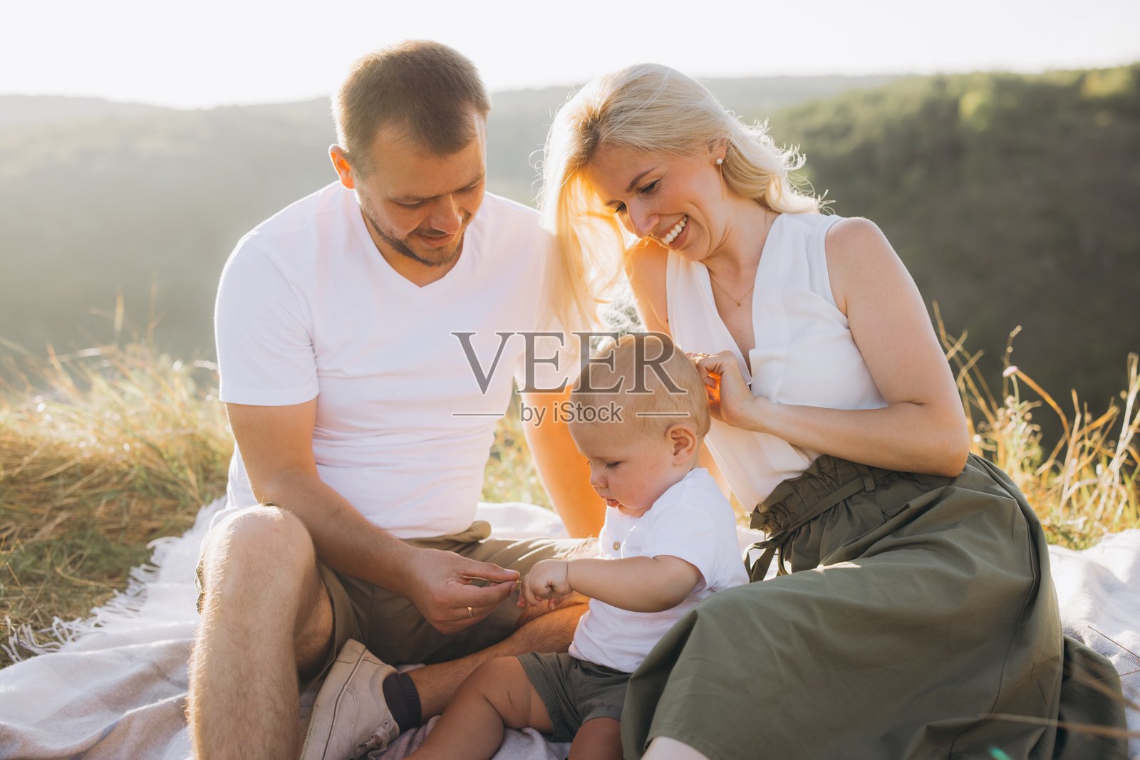 快乐的家庭在阳光明媚的日子里享受宁静的户外野餐照片摄影图片